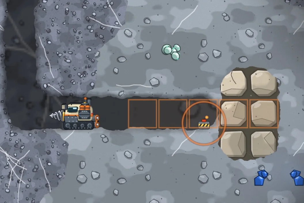 In grey bedrock, a charge sits in a tunnel next to a wall of big boulders